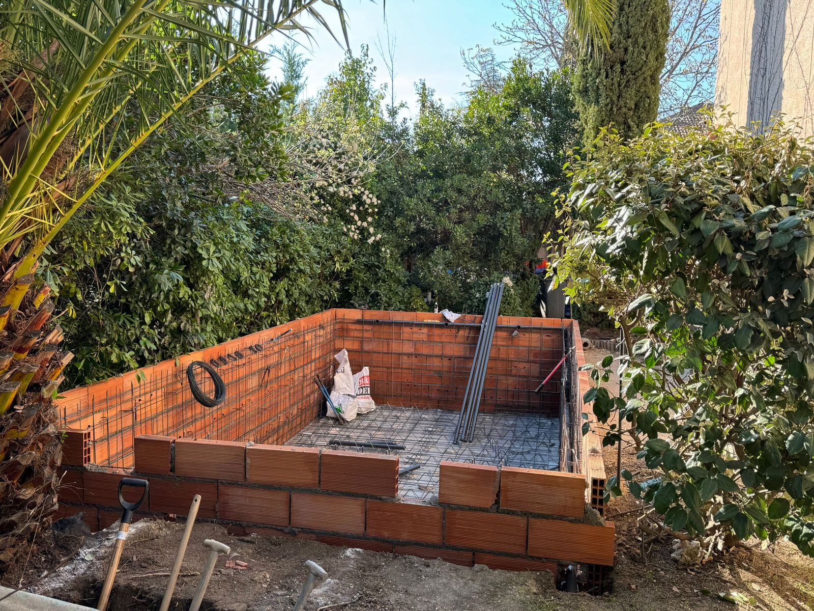 Construcción de piscina con encofrado de ladrillo y ferralla antes del gunitado