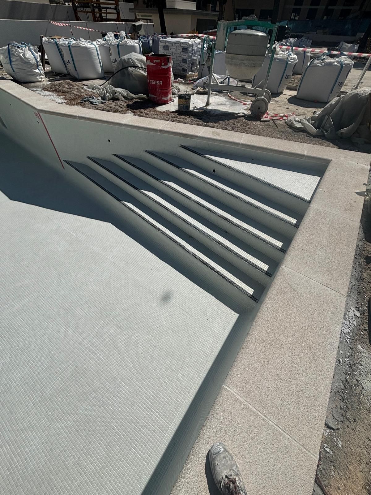 Escalera de piscina de obra recién gunitada, con los peldaños formados en hormigón proyectado