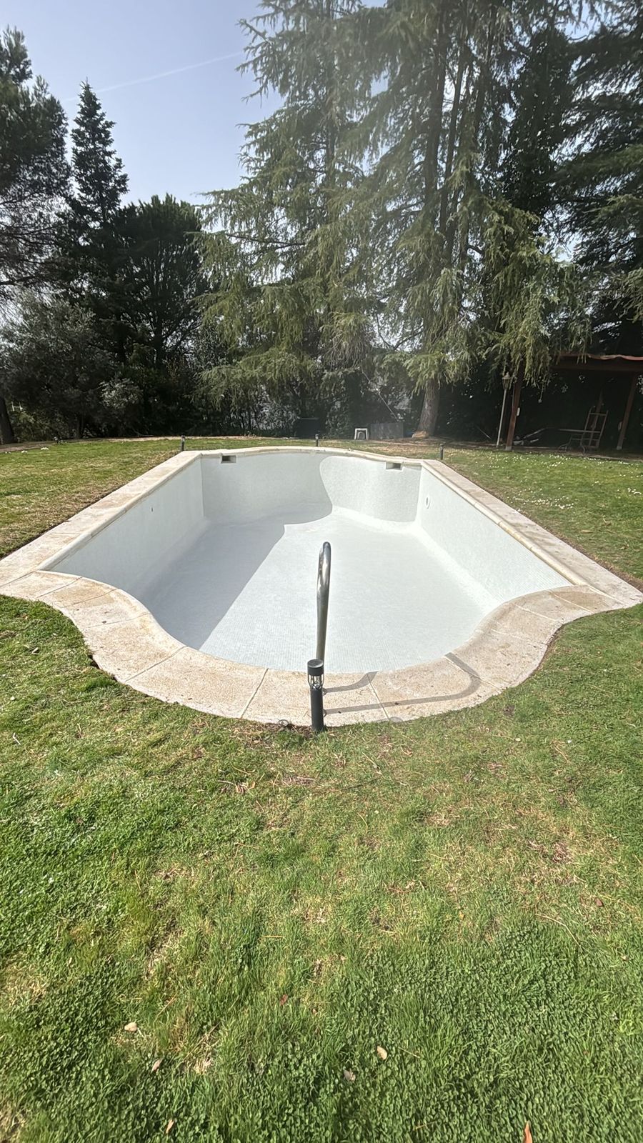 Vaso de piscina de obra terminado con escalera romana semicircular en el testero