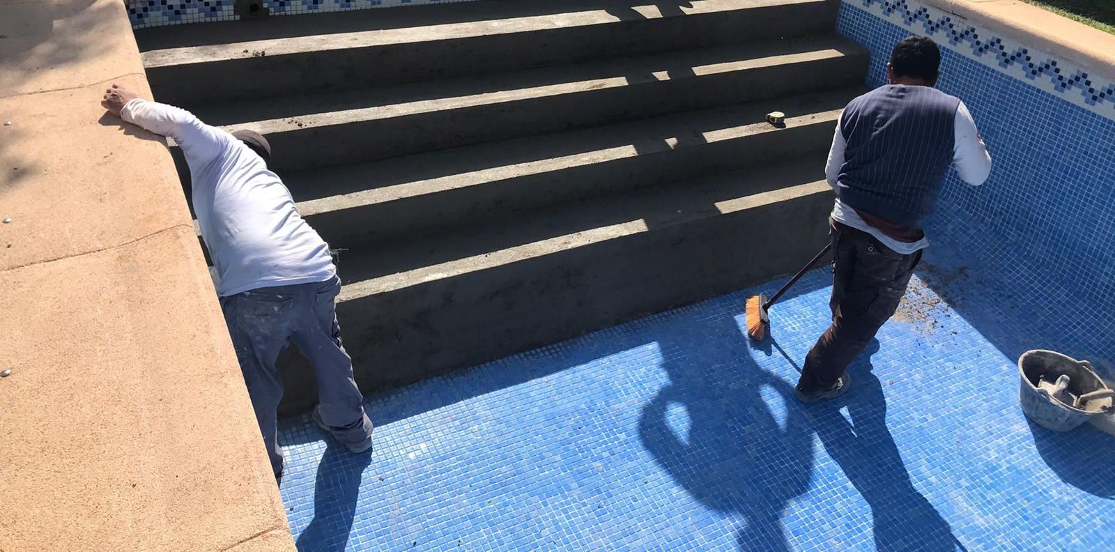 Escalera de piscina en plena reforma, con los peldaños picados y el soporte preparado