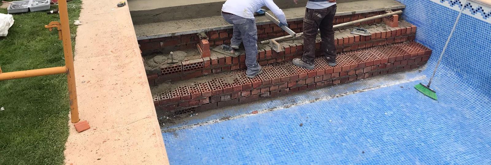 Escalones de una piscina en ejecución, con el ladrillo colocado y la cenefa de gresite ya rematada