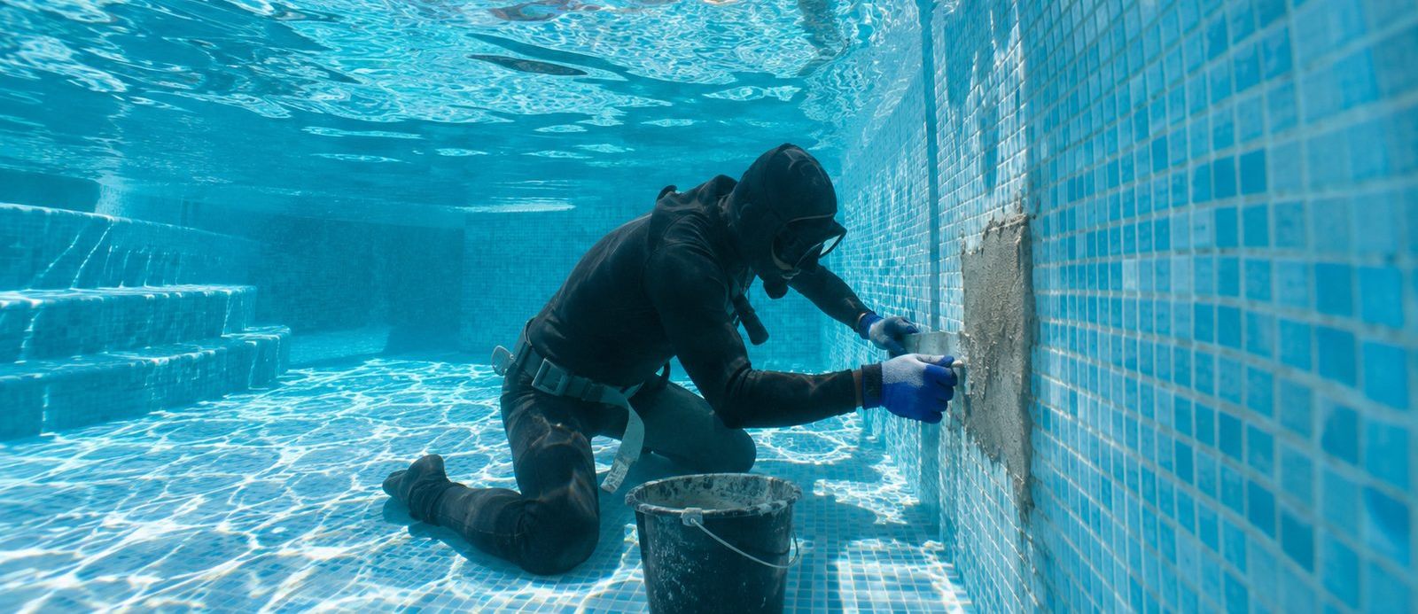 Buceador reparando una fuga en la piscina sin necesidad de vaciarla