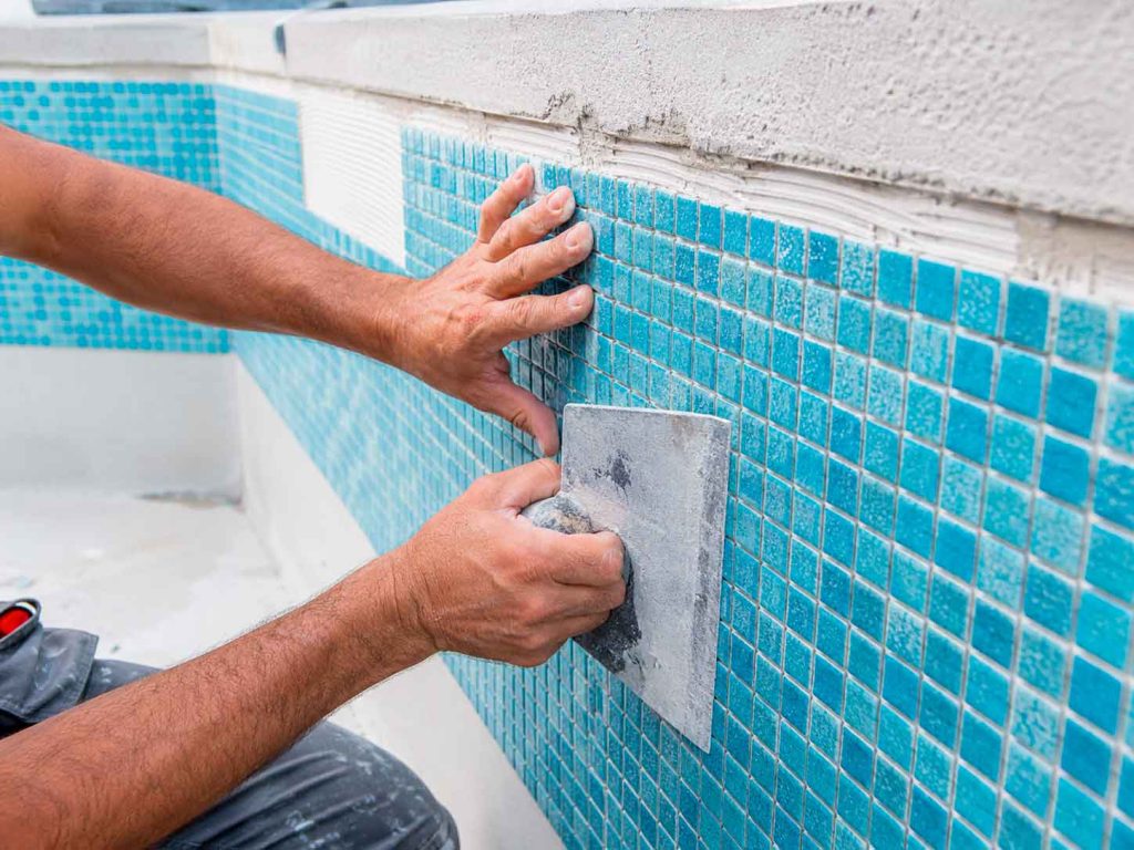 Instalación de gresite azul en revestimiento de piscina
